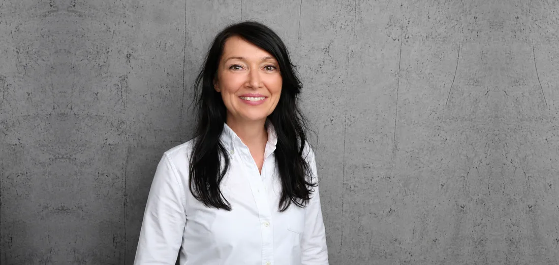 Liane Willinghöfer, melino's Head of Royalty Accounting, standing against a bare concrete wall